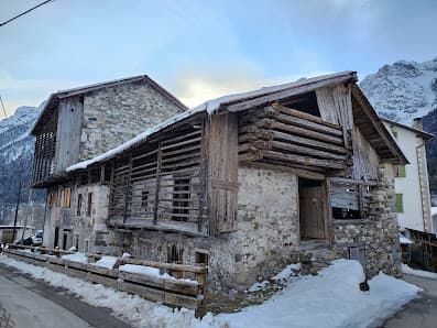 Image of a chalet nestled in the mountains of Forni di Sopra, Udine, Italy. The winter sports centre and ski resort make a picturesque winter scene.