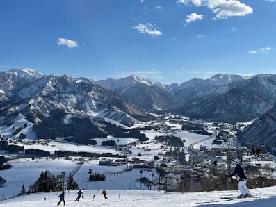 Vibrant winter scene at the Iwappara ski resort in Honshu, Japan, showcasing captivating snowfall and skiers enjoying the slopes.