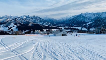 Winter scene at Iwappara Ski Resort in Niigata, Japan, showcasing a bustling ski slope, a chalet, and stunning snow-covered scenery.