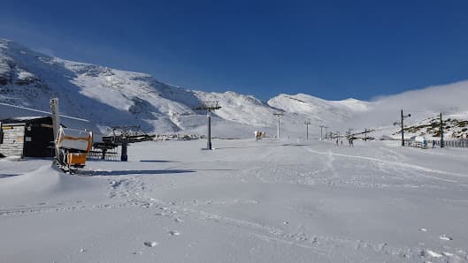 View of Alto Campoo in Cantabria, Spain showcasing a bustling winter sports centre and a cosy chalet amidst a serene ski resort setting. A picturesque winter scene fit for adventurous skiing activities.