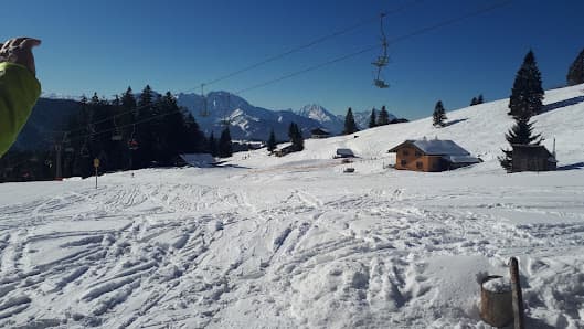 Winter scene at a ski resort in Gaissau-Hintersee, Austria, featuring the sight of a charming chalet amidst a mountainous winter sports landscape.
