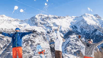 Winter sports scene at Pelvoux Vallouise ski resort in Hautes-Alpes, France, featuring a skier and group of people skiing.