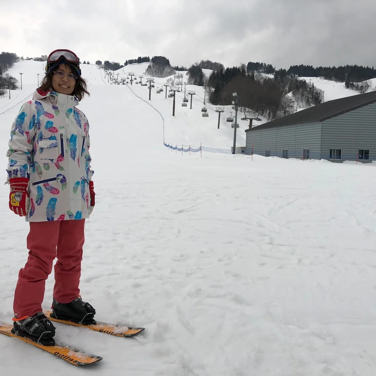 Chokai Kogen Yashima in Japan - a little girl standing on a snowboard in the snow.