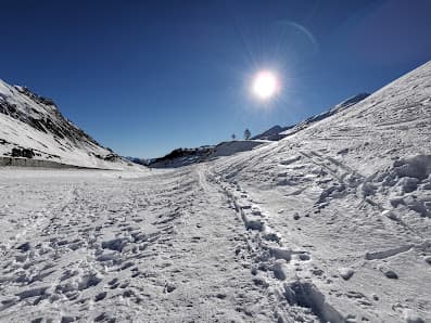 Winter sports scene in Argentera, Piedmont, Italy showcasing a charming chalet nestled amidst stunning, snow-blanketed mountainous scenery.
