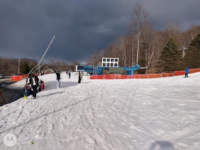 Winter sports scene at Shawnee Mountain in East Stroudsburg, PA with skiers and a ski lift in the snowy landscape of the resort.