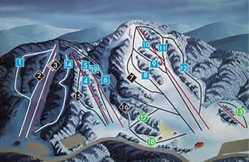A vista of Mont Cascades ski resort in Quebec, Canada, featuring a ski lift carrying eager skiers up the snow-covered slopes, with a challet nestled amongst the wintry scenery.