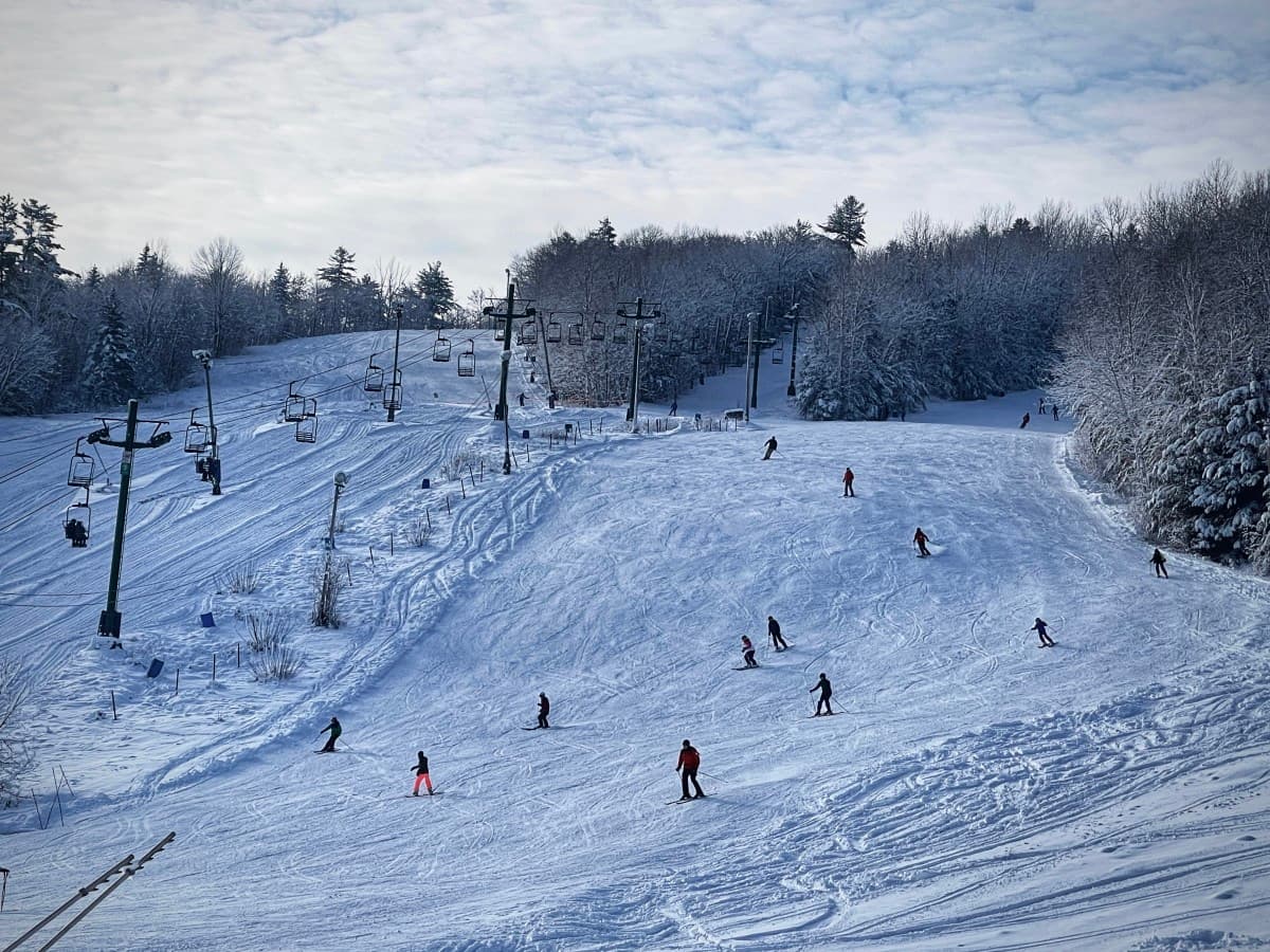 Mont Cascades in Canada - a group of people skiing down a snowy hill.