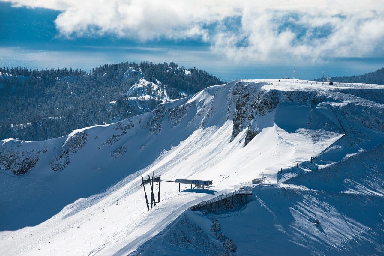 Palisades Tahoe in USA - a snowy mountain with a ski lift going up the side.